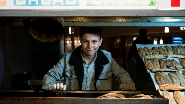 Young person working at a bakery counter